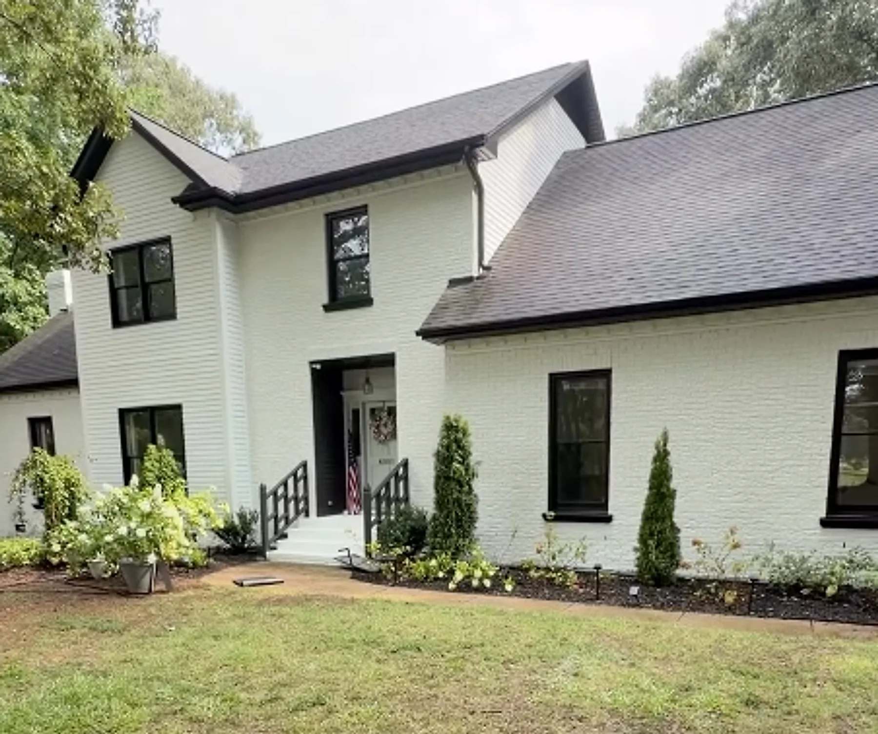 Red brick home painted crisp white with black trim, exterior painting in the Greater Charlotte Area